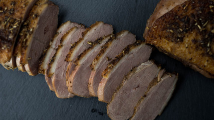 Pieczona kaczka pocięta na plastry. Zbliżenie, ciemne tło. © PhotoHunter