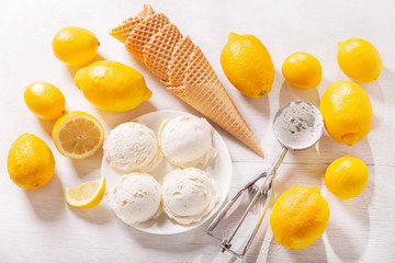 lemon ice cream scoops with waffle cones and fresh fruits, top view