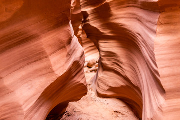 Orange red wave shape formations rocks shadows view at narrow Antelope slot canyon in Arizona on path footpath trail from Lake Powell