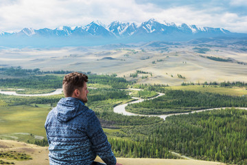 Man watching to glacier in Altai mountains. Resting in mountains or global warming concept