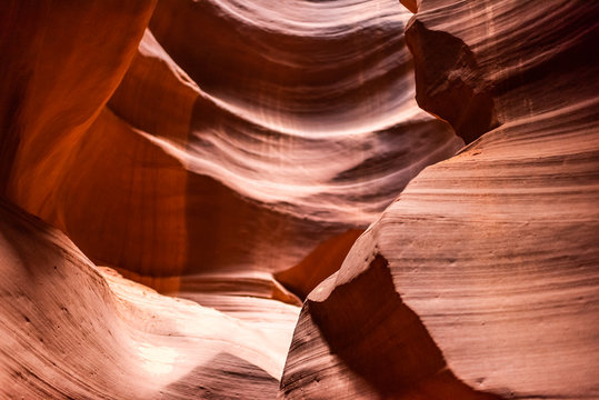 Abstract closeup view of shadows and light at upper Antelope slot canyon with wave shape formations of red rock layers sandstone in Page, Arizona