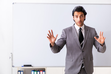 Young handsome businessman in front of whiteboard