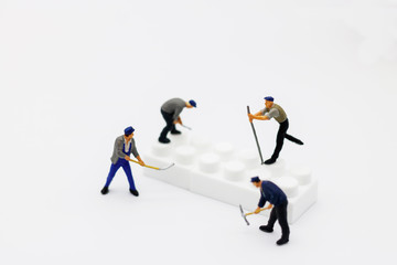 Miniature people: Worker digging white box. Service,  repair and  maintenance concept.