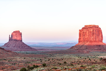 Merrick and mittens butte formations with red pink rock color in Monument Valley canyons during sunset sunlight in Arizona