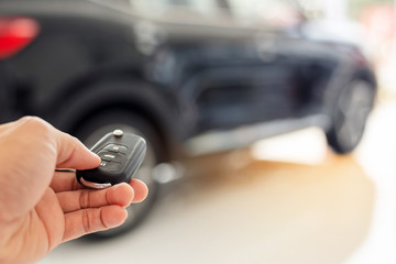 Man hand open the car with car remote key at car park,Men's hand presses on the remote control car alarm systems.