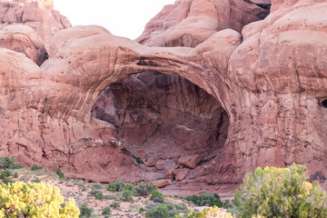 Double arch in Arches National Park in Utah during morning sunrise with red pink rock color and unique formation