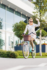 Young happy woman riding a bicycle in the city