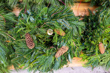 Obraz premium Closeup of green christmas wreaths mistletoe on display in holiday season festive christmas store shop with pine cones