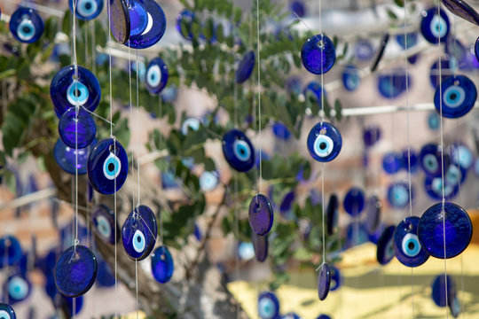 Close up of evil eye beads hanging on rope at the tree. Superstition evil eye.