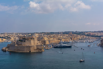 Obraz premium View to the Fort St. Angelo, with part of the city Birgu (Vittoriosa), and to the Grand Harbour Marina full with luxury yachts and ships. View to the Fort St. Angelo from Valletta, Malta.