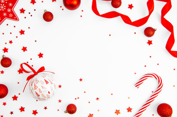 Christmas post card mockup with copy space made of red candy canes, stars, glass balls on white background. Flat lay. Top view