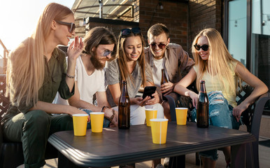 Cheerful youngsters posting photos of their party in social media