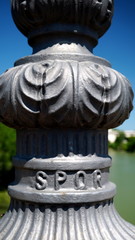 Detail of cast iron lamppost stand on a bridge with SPQR written, and blurred background on a sunny...