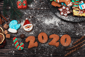 Fototapeta na wymiar Different ginger cookies for new 2020 year holiday on wooden background, xmas theme