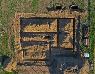 Aerial drone top down view on construction site with excavated hummus ground prepared for house foundation concrete pouring