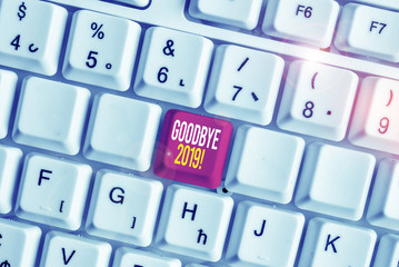 Word writing text Goodbye 2019. Business photo showcasing express good wishes when parting or at the end of last year White pc keyboard with empty note paper above white background key copy space