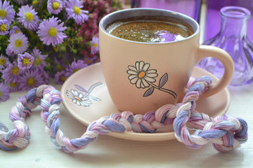 Plank white desk in vintage style with purple flower and cup of coffee