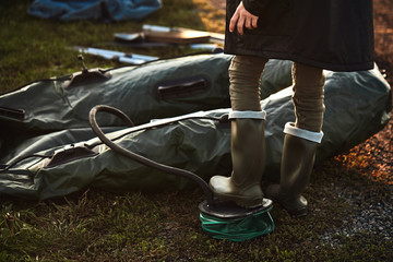 Teen boy ready inflatable boat to go fishing on lake