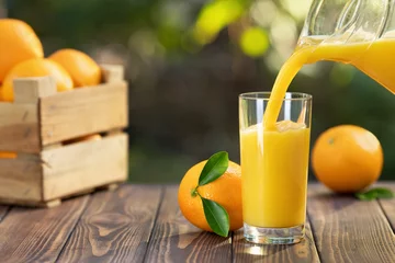 Fotobehang orange juice pouring in glass © alter_photo