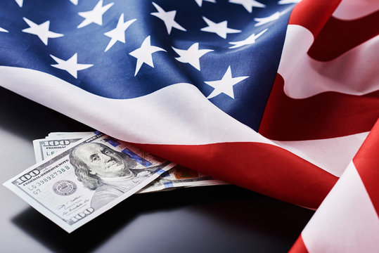 USA national flag and currency usd money banknotes on a dark background. Business and finance concept