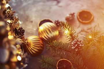 Fototapeta na wymiar Christmas decorations with golden balls, fir tree branch and garland lights on a dark background