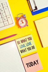 Conceptual hand writing showing Do What You Love Love What You Do. Concept meaning Pursue your dreams or passions in life Crumpled white paper on table clock mobile and pc keyboard