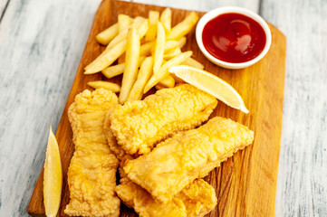 fish and chips with french fries, on wooden background 
