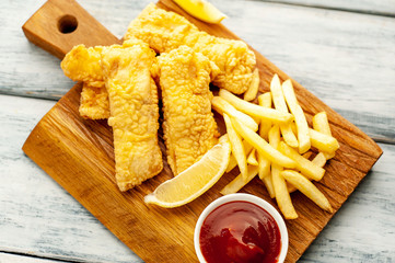 fish and chips with french fries, on wooden background 