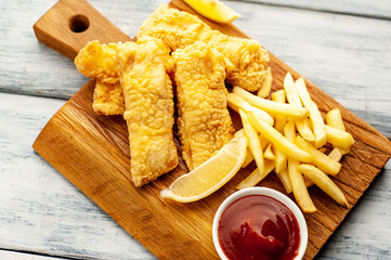 fish and chips with french fries, on wooden background 