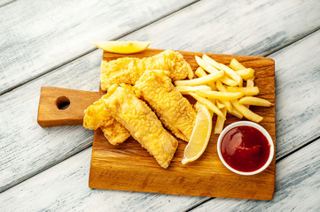 fish and chips with french fries, on wooden background 