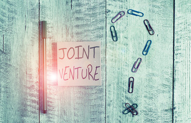 Word writing text Joint Venture. Business photo showcasing Collaboration Arrangement Parties Partnership Team Pastel colour note paper placed next to stationary above the wooden table