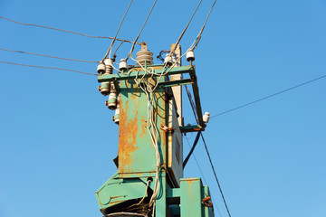 Power lines with various poles and supports, the appearance of an electrical transformer booth.