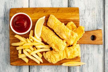 fish and chips with french fries, on wooden background 
