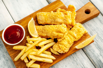 fish and chips with french fries, on wooden background 