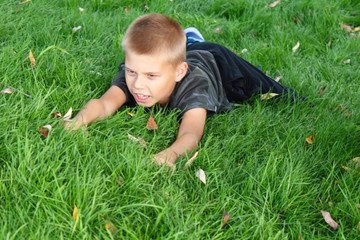 The boy climbs on the grass. Funny children's games in the grass.
