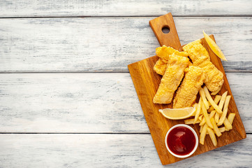 fish and chips with french fries, on wooden background 