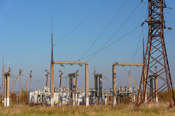 Power lines with various poles and supports, the appearance of an electrical transformer booth.