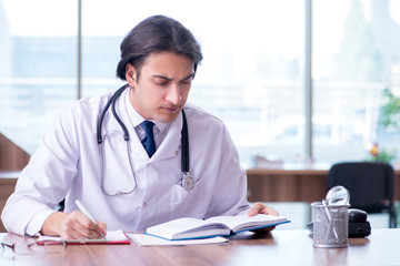 Young handsome doctor working in the clinic