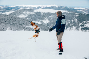 Lone trekker with his dog in snow.