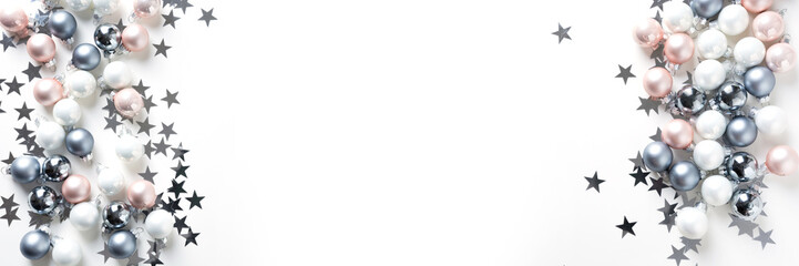 Christmas banner made of pastel colorful baubles on white. Xmas. Flat lay. Top view with copy space.