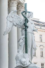 Beautiful winged angel of Baroque Era with a cross at Saint Karl Cathedral in Vienna, Austria