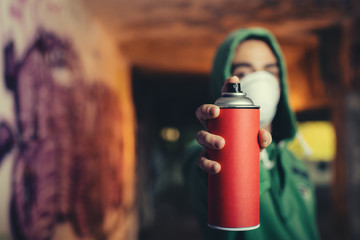 Graffiti artist pointing the spray to camera