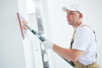 Painter work angle sander. sanding the wall corner surface after putty for painting