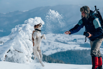 Lone trekker with his dog in snow.