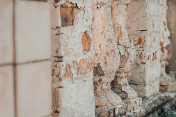 Pale pink cracked old fence columns of a building.