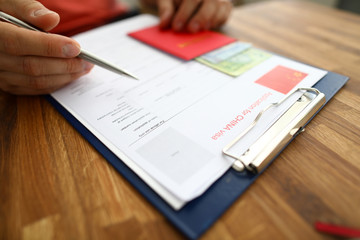 Male hand hold silver pen with passport