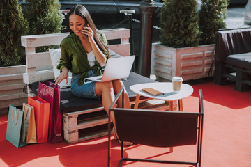Smiling pretty woman is looking on shopping bags