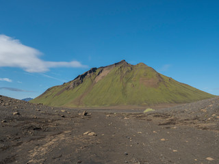 Volcanic desert landscape with green Hattafell mountain with footpath of Laugavegur trail. Fjallabak Nature Reserve, Iceland. Summer blue sky