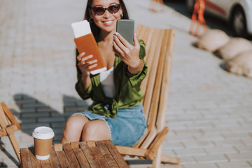 Happy Asian woman is making selfie outdoors