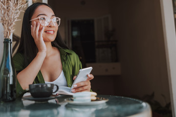 Asian pretty woman is looking away in cafe